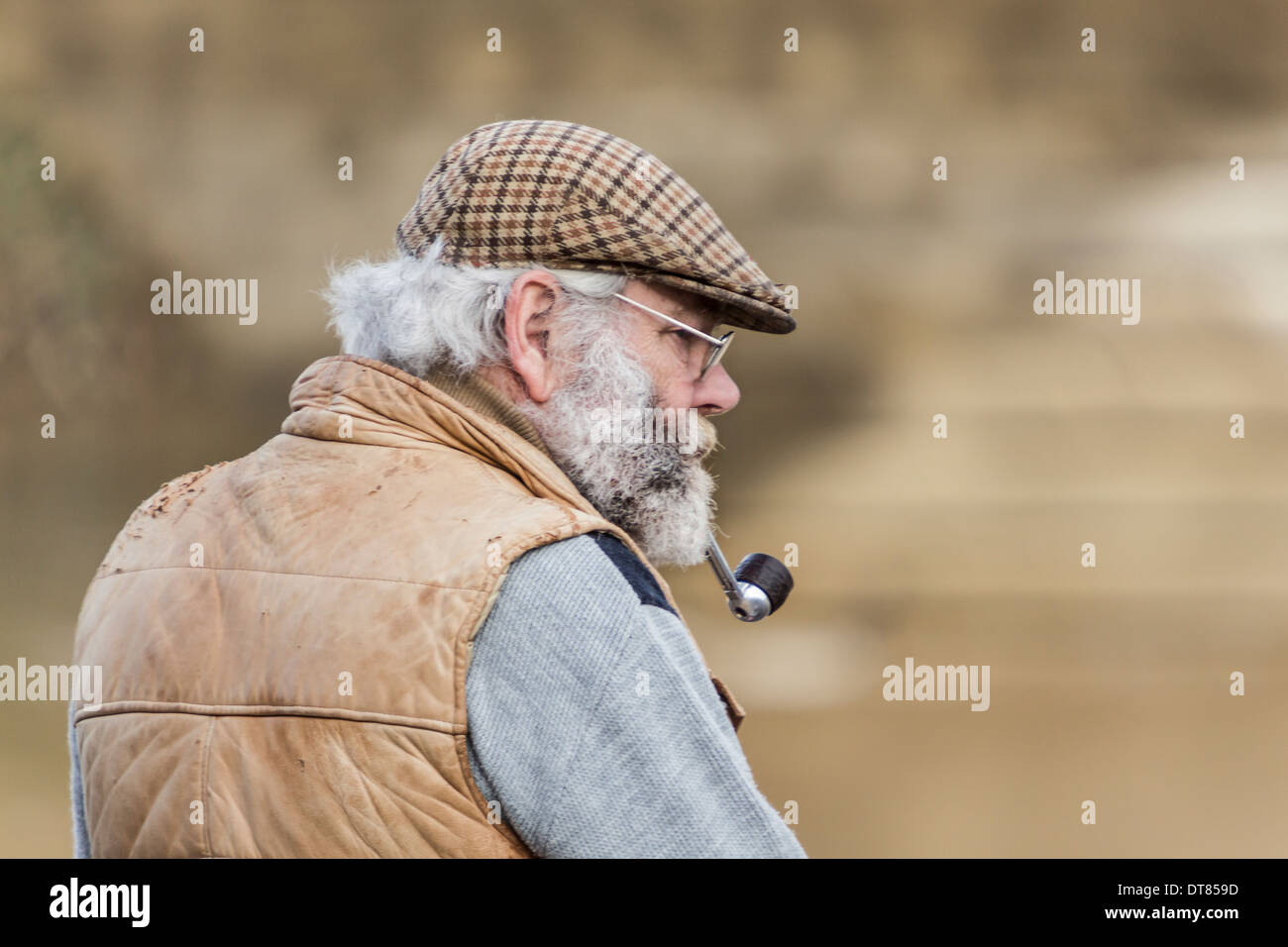 Older gentleman thinking while smoking a pipe Stock Photo