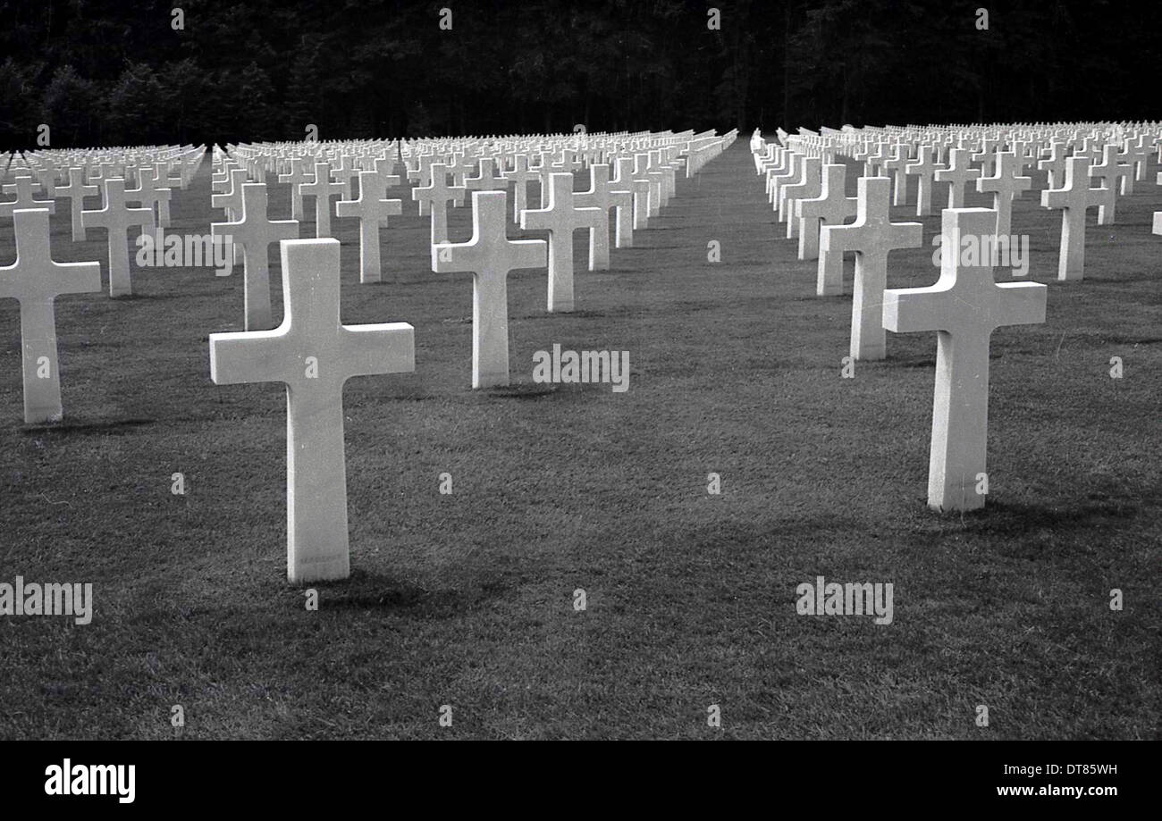 1960s historical, rows of crosses in a field of remembrance at the Normandy American Cemetery and Memorial, Normandy, France. Located in Colleville-Sur-Mer, approx 10,000 white crosses point towards  America in a memorial that honours American troops who died in Europe during WW2. Operated by the American Battle Monuments Commission (ABMC) it was dedicated in 1956. Stock Photo