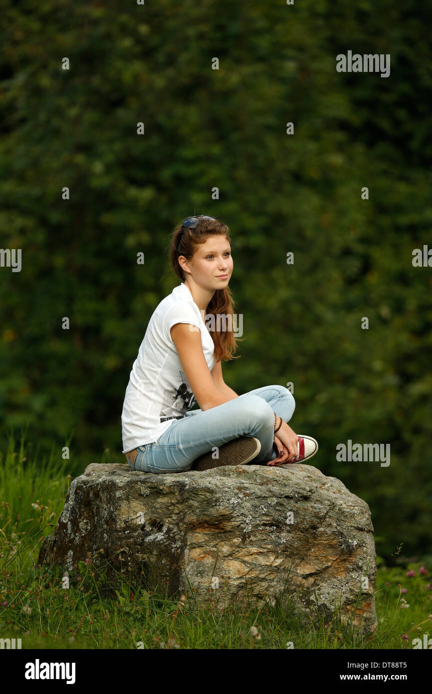 Young girl siting on a stone. Stock Photo