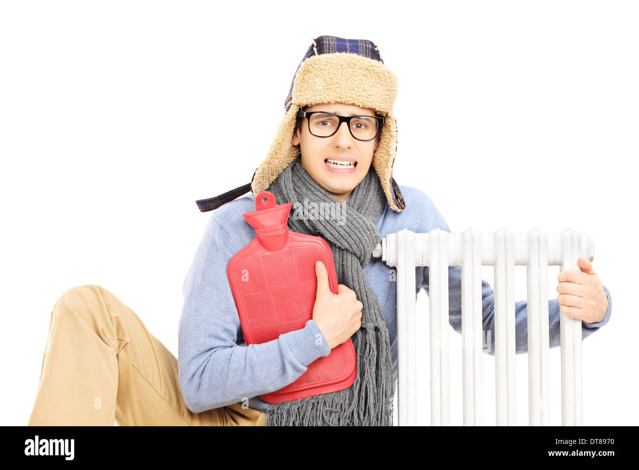 Chilled young man with hot water bottle hugging a radiator Stock Photo ...