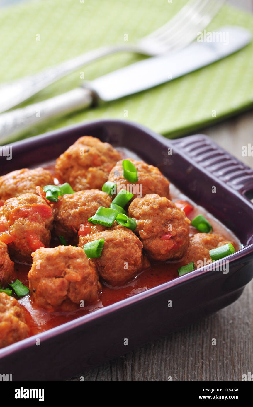 Spanish meatballs in ceramic baking mold on wooden background Stock Photo