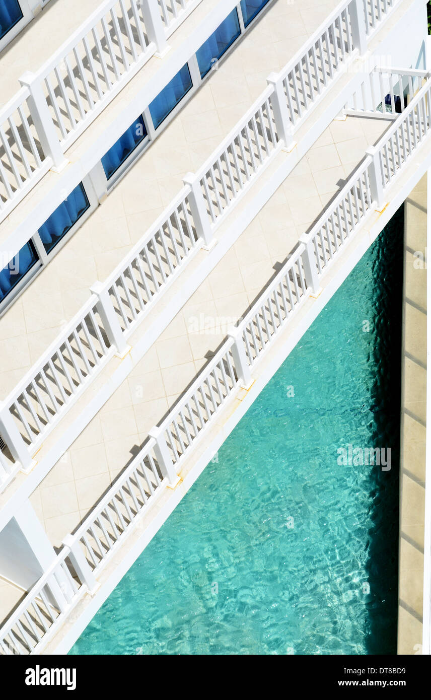 Resort floors with balconies looking down into a swimming pool Stock Photo