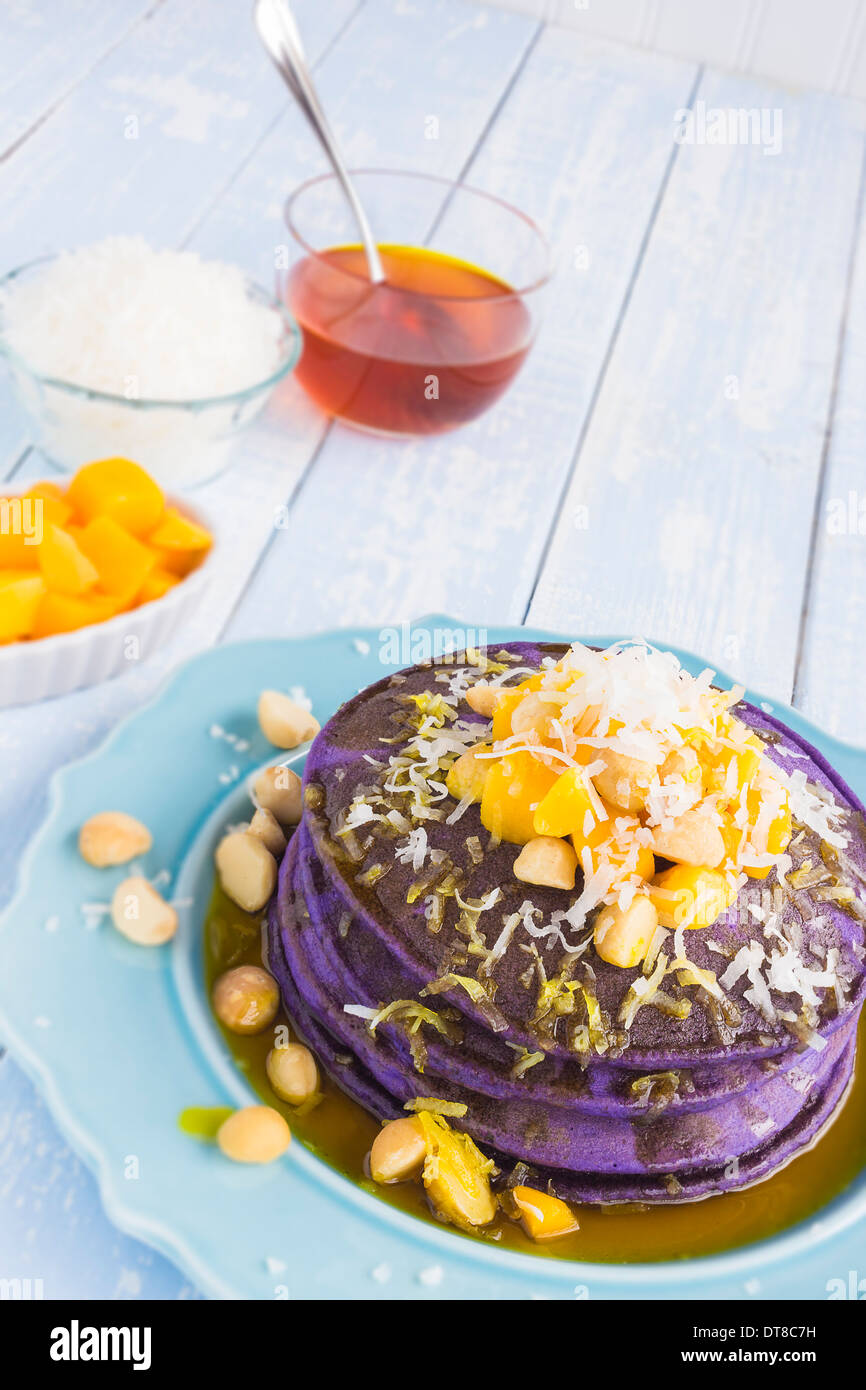 Taro pancakes topped with mango, macadamia nuts, shredded coconut and lilikoi syrup Stock Photo
