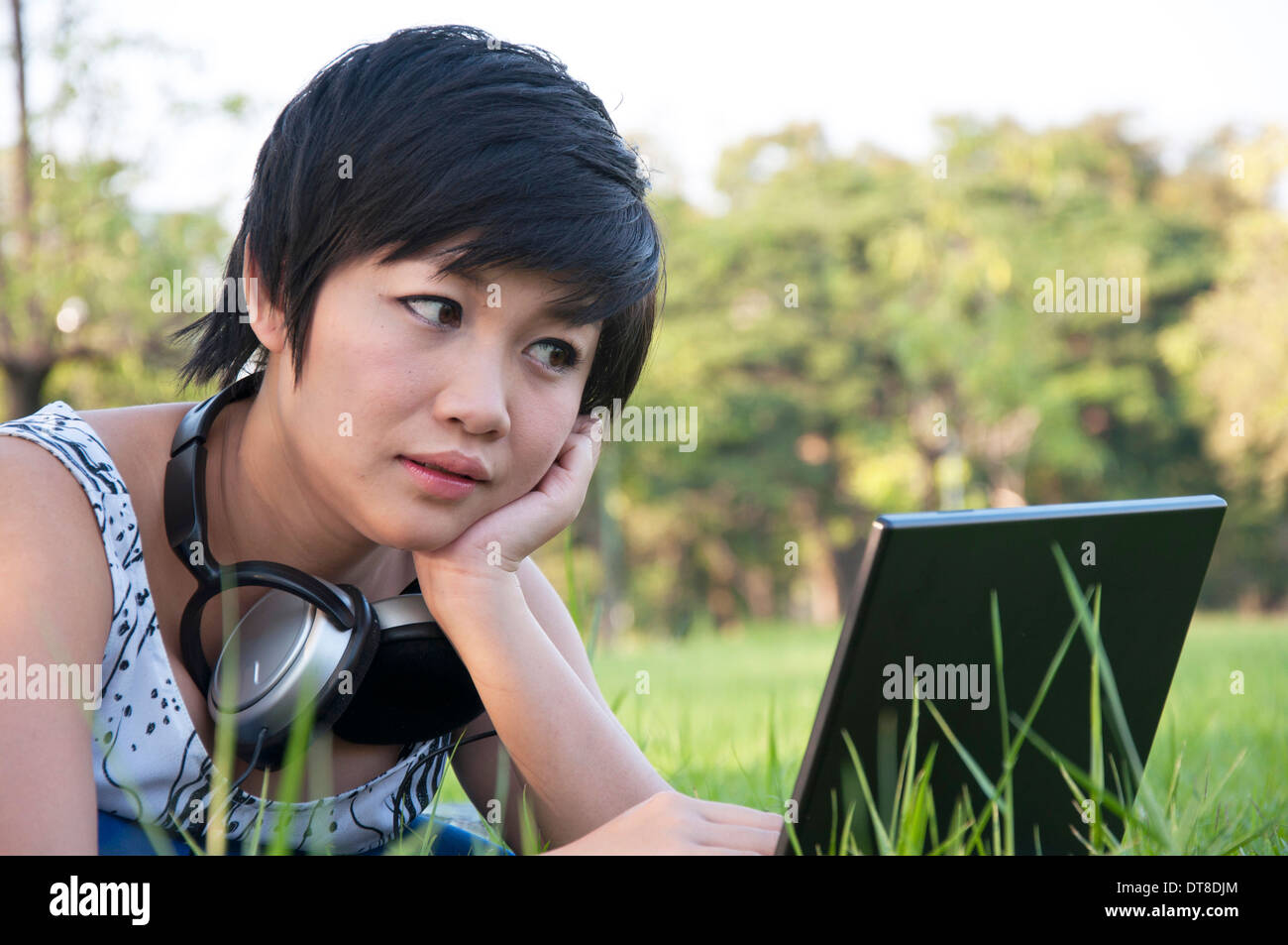 Asian lady using computer in a field Stock Photo - Alamy