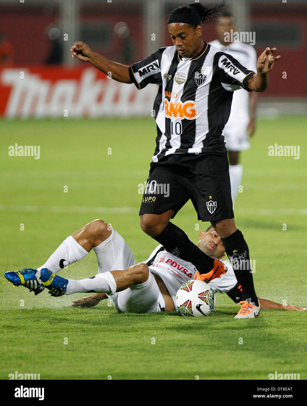 Barinas, Venezuela. 11th Feb, 2014. Ronaldinho (top) of Brazil's Atletico Mineiro vies for the ball during the Copa Libertadores soccer match against Venezuela's Zamora at La Carolina Stadium, in Barinas, Venezuela, on Feb. 11, 2014. © Elyxandro Cegarra/Xinhua/Alamy Live News Stock Photo