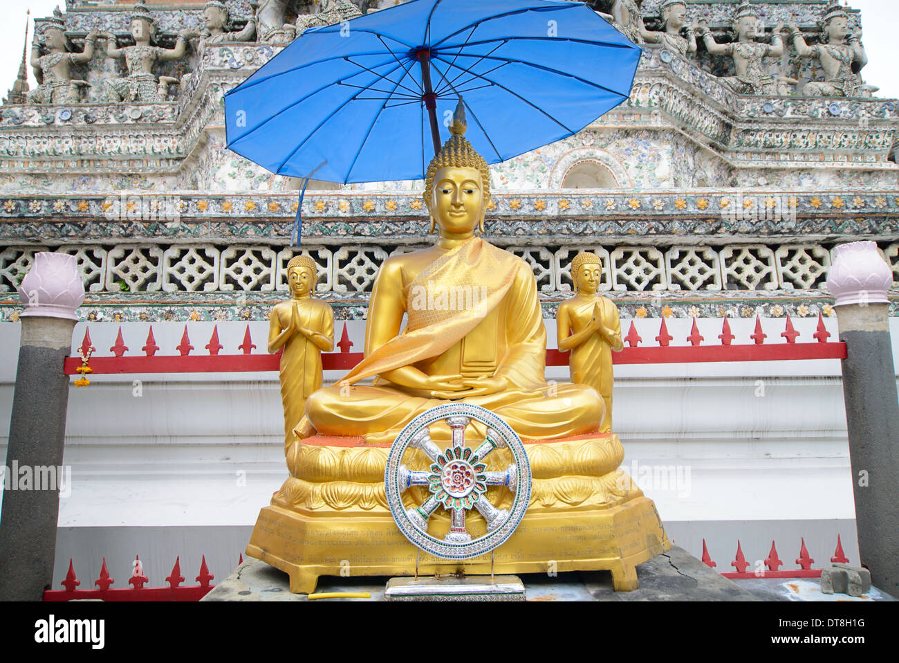 3 Buddha golden statues under a blue umbrella at Wat Arun temple, Bangkok, Thailand Stock Photo