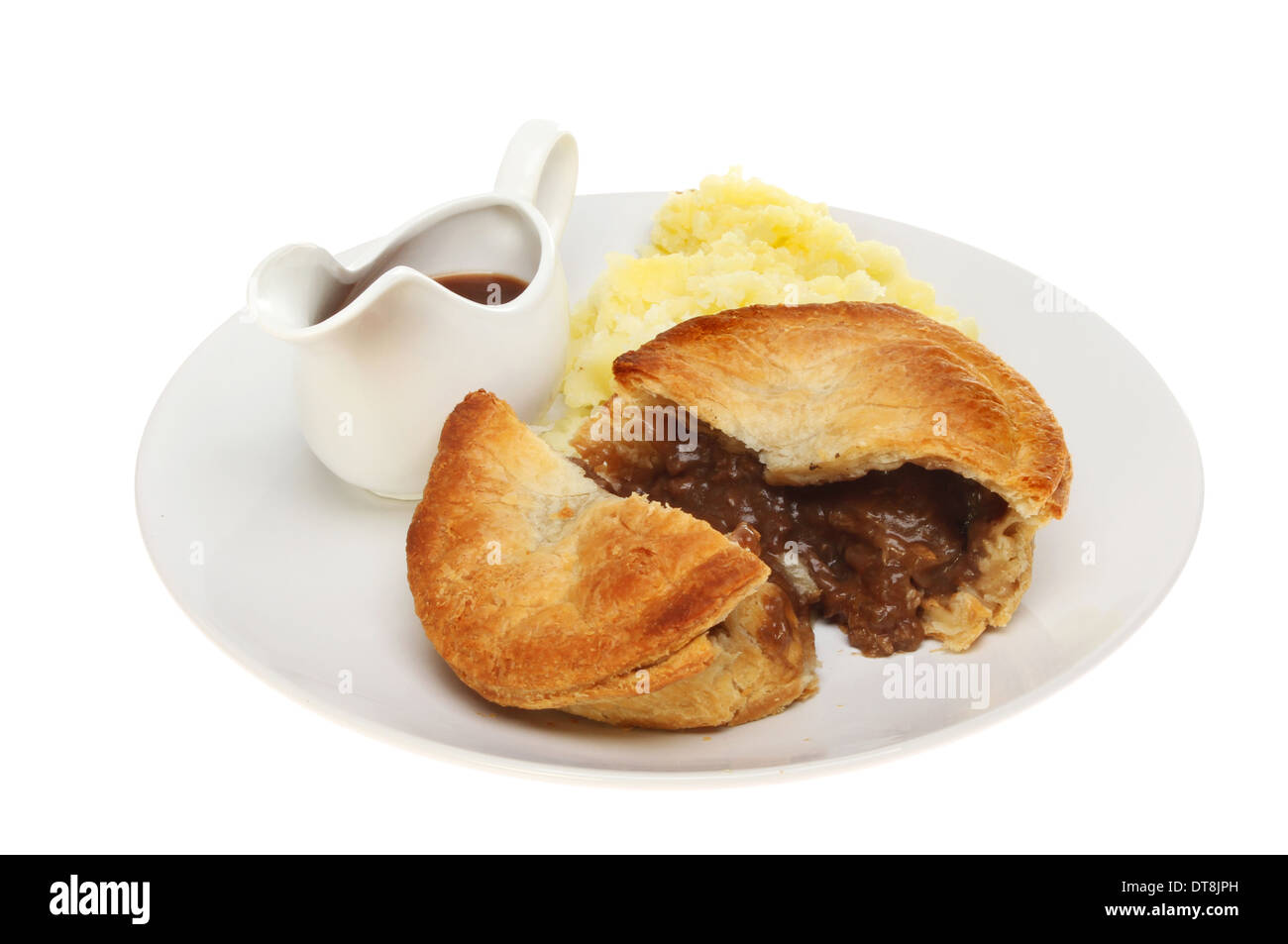 Meat pie mashed potato and gravy in a jug on a plate isolated against white Stock Photo