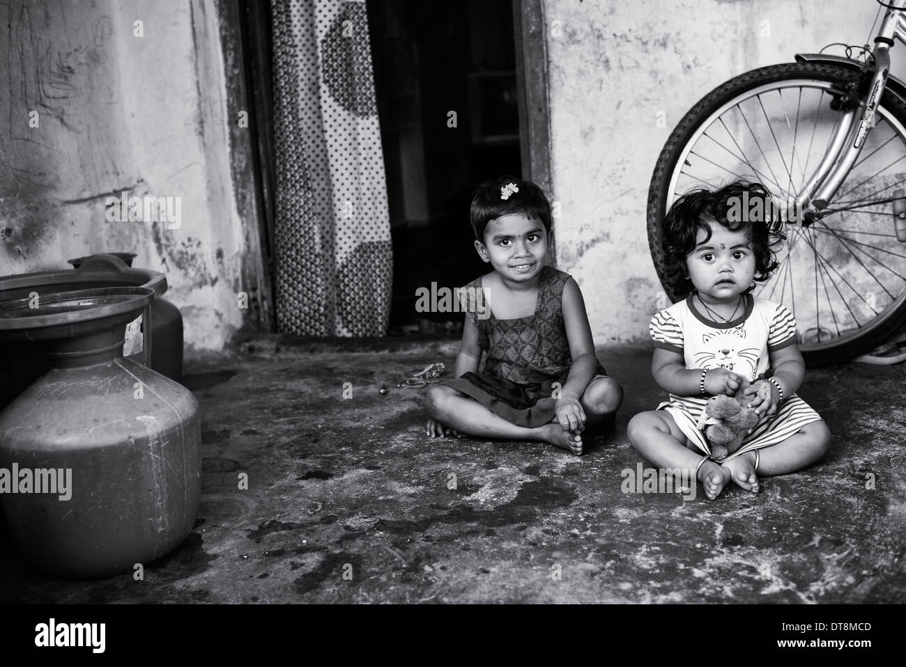 Two Indian infant girls outside their town house. Andhra Pradesh, India. Monochrome Stock Photo