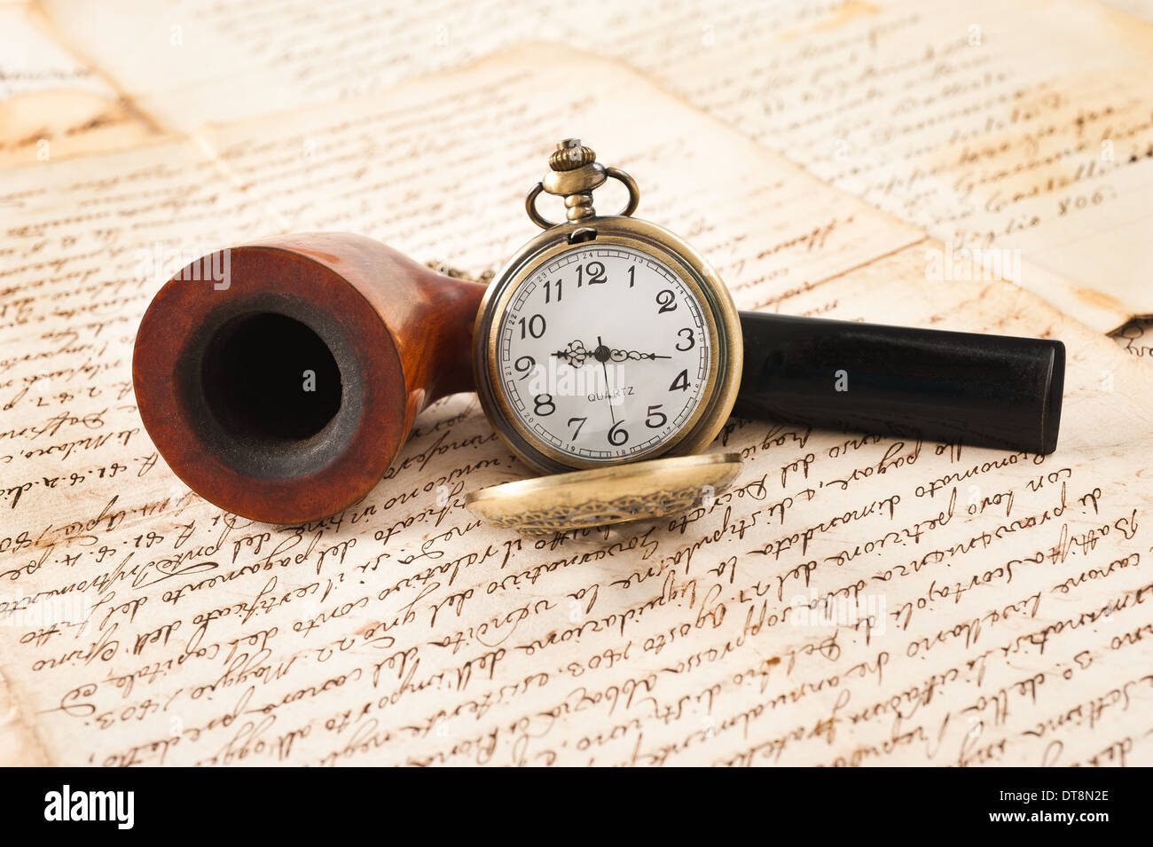 pipe and pocketwatch on letters background Stock Photo