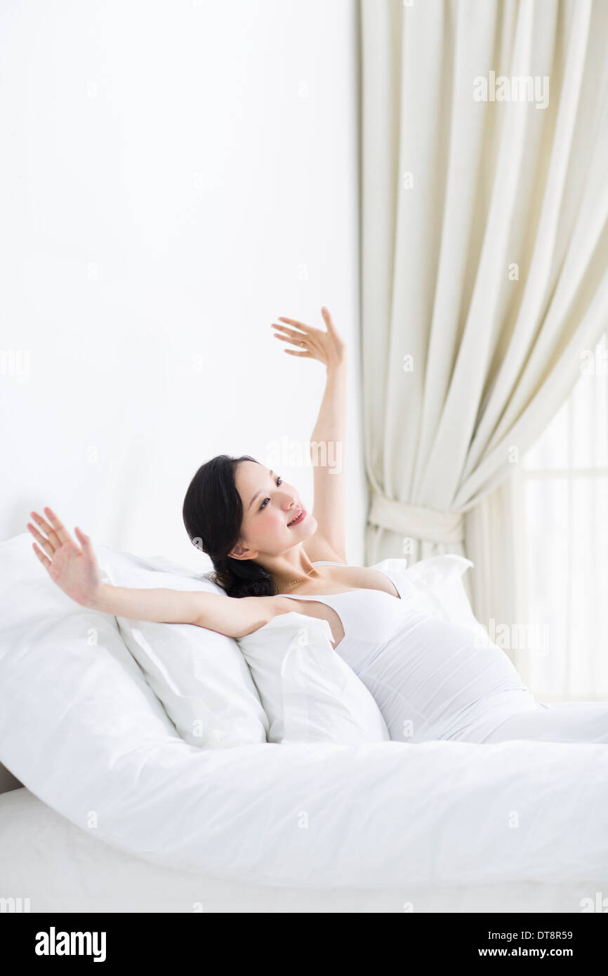 Pregnant woman waking up and stretching Stock Photo Alamy
