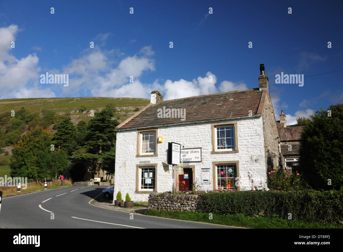 A cottage restaurant and shop beside a road with hills behind. Stock Photo
