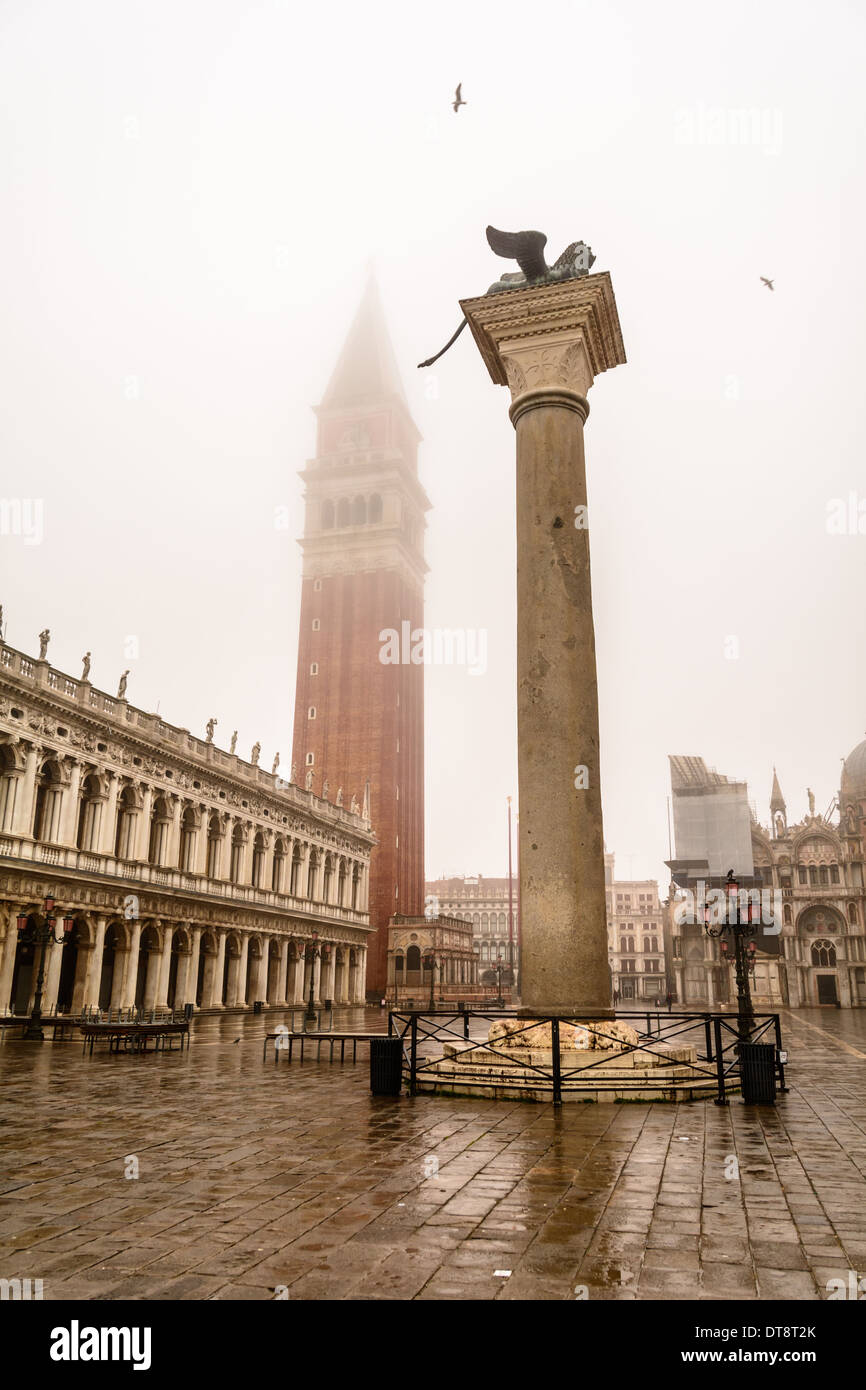 Venice, Italy. The Campanile, belltower, of St Mark´s square, covered in fog and the eastern column with the winged Lion of Venice, Piazzetta San Marco. Flying seagulls. Stock Photo