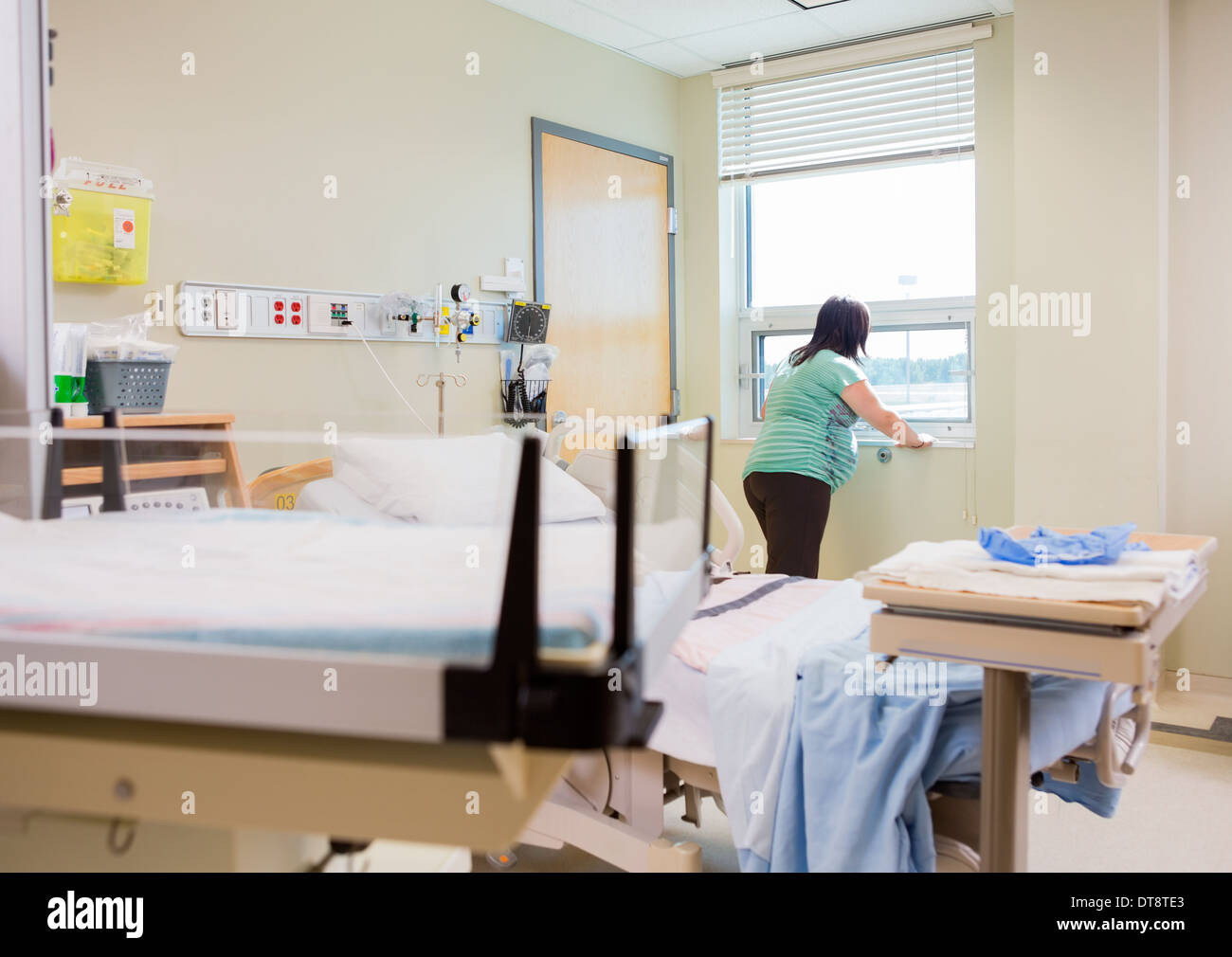 Pregnant Woman At Window In Hospital Room Stock Photo