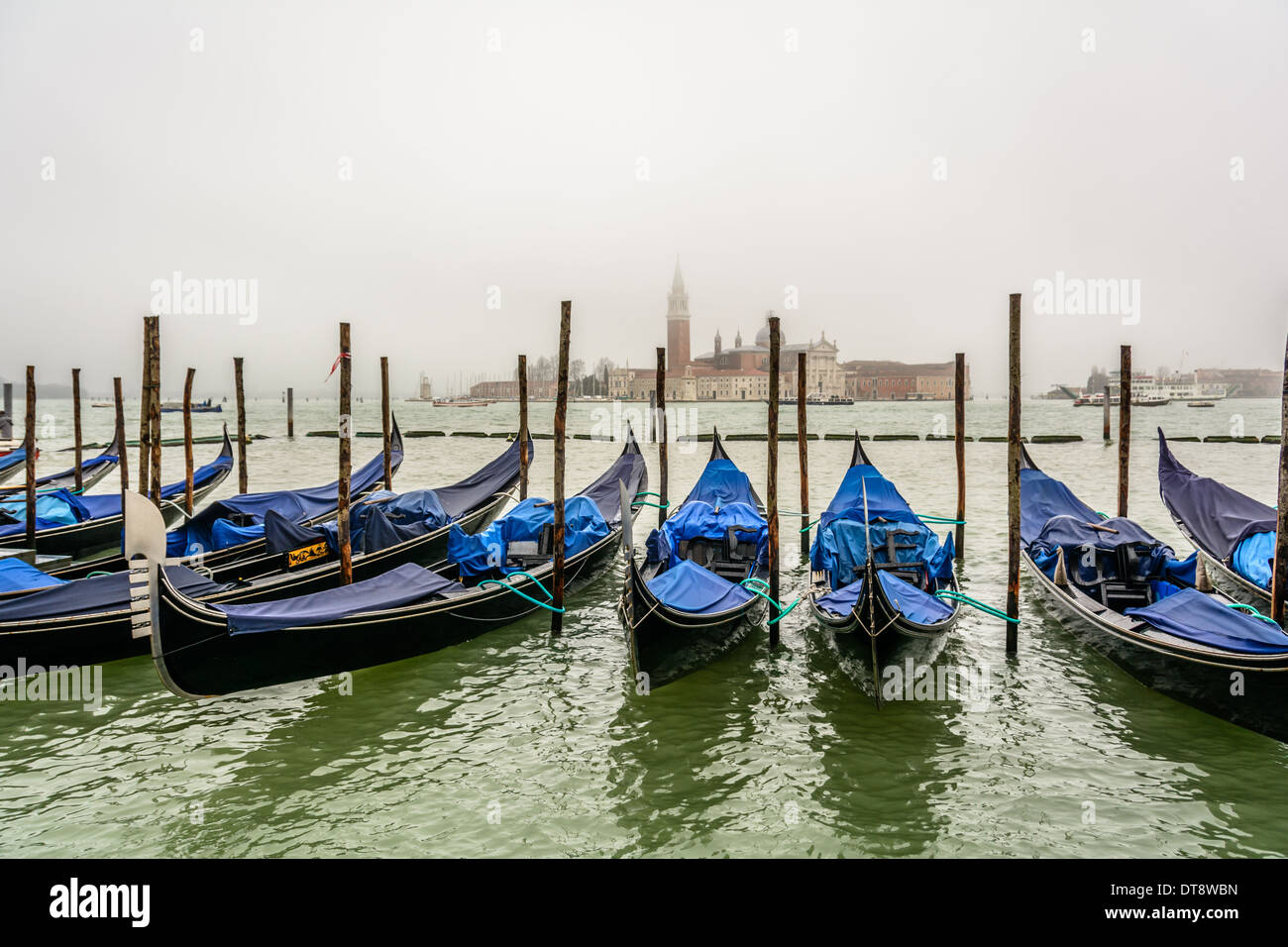 Venice, Italy. Popular view with Venetian gondolas in foreground and San Giorgio Maggiore island in the background at an overcast rainy day. Stock Photo