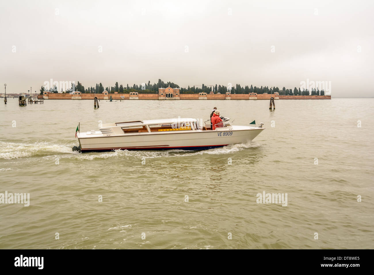 Venice, Italy. A Venetian water taxi speedboat, taxi acquei, motoscafo, passing San Michele Cemetery island. Stock Photo