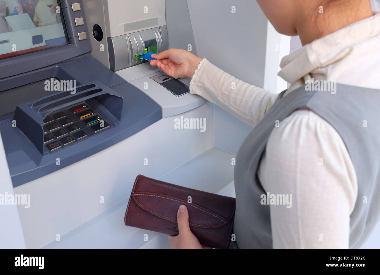 Asian woman at ATM Stock Photo