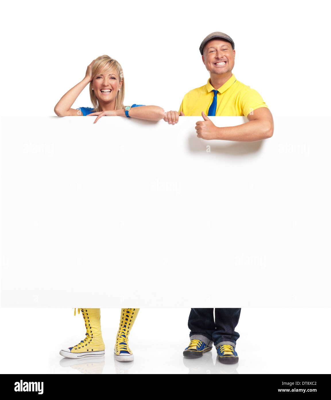 Happy smiling man and woman standing behind a large white blank sign with copy space Stock Photo