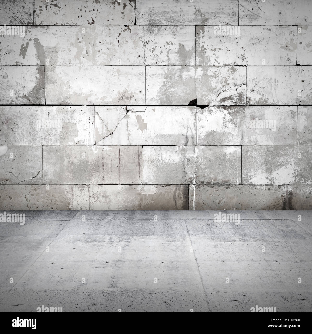 Interior with old damaged stone wall and concrete floor Stock Photo