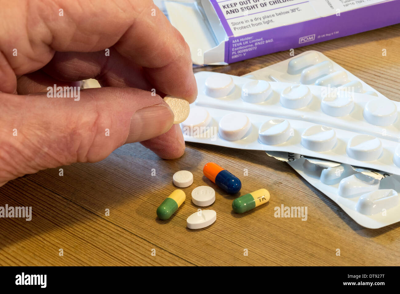 Elderly man's hand with selection of pills for daily medication. Stock Photo