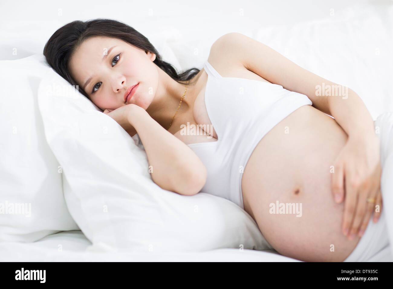 Pregnant woman lying in bed Stock Photo