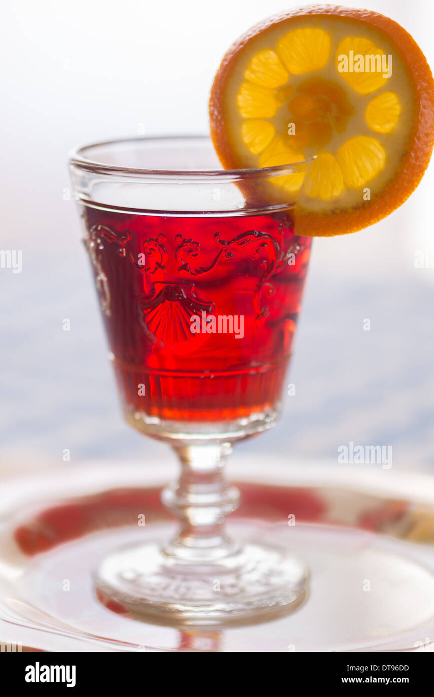 Pomegranate juice, garnish with an orange slice. Stock Photo