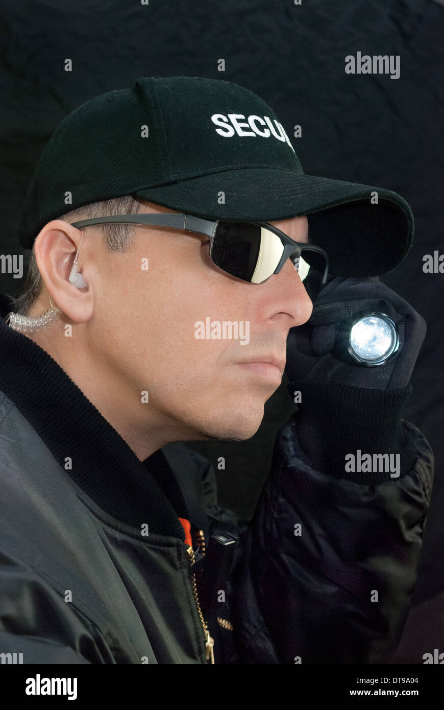 Close-up of a security guard searching with his flashlight. Stock Photo