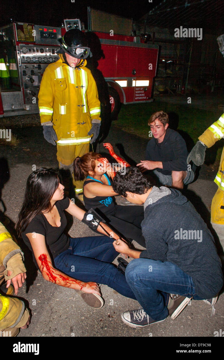 Regional Occupation Program (ROP) students perform first aid on classmates posing as crime victims in crime investigation class. Stock Photo