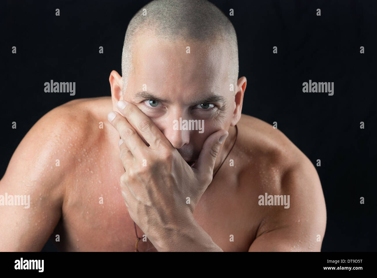 Confident man looking to camera, shiirtless, shaved head Stock Photo