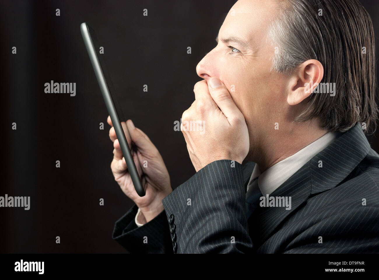 Close-up of a businessman looking at his tablet amazed Stock Photo