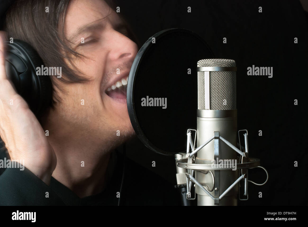 Close-up of a man recording vocals in a sound studio. Stock Photo