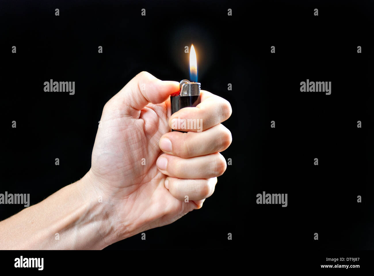 Close-up of a man's hand holding a lit lighter. Stock Photo