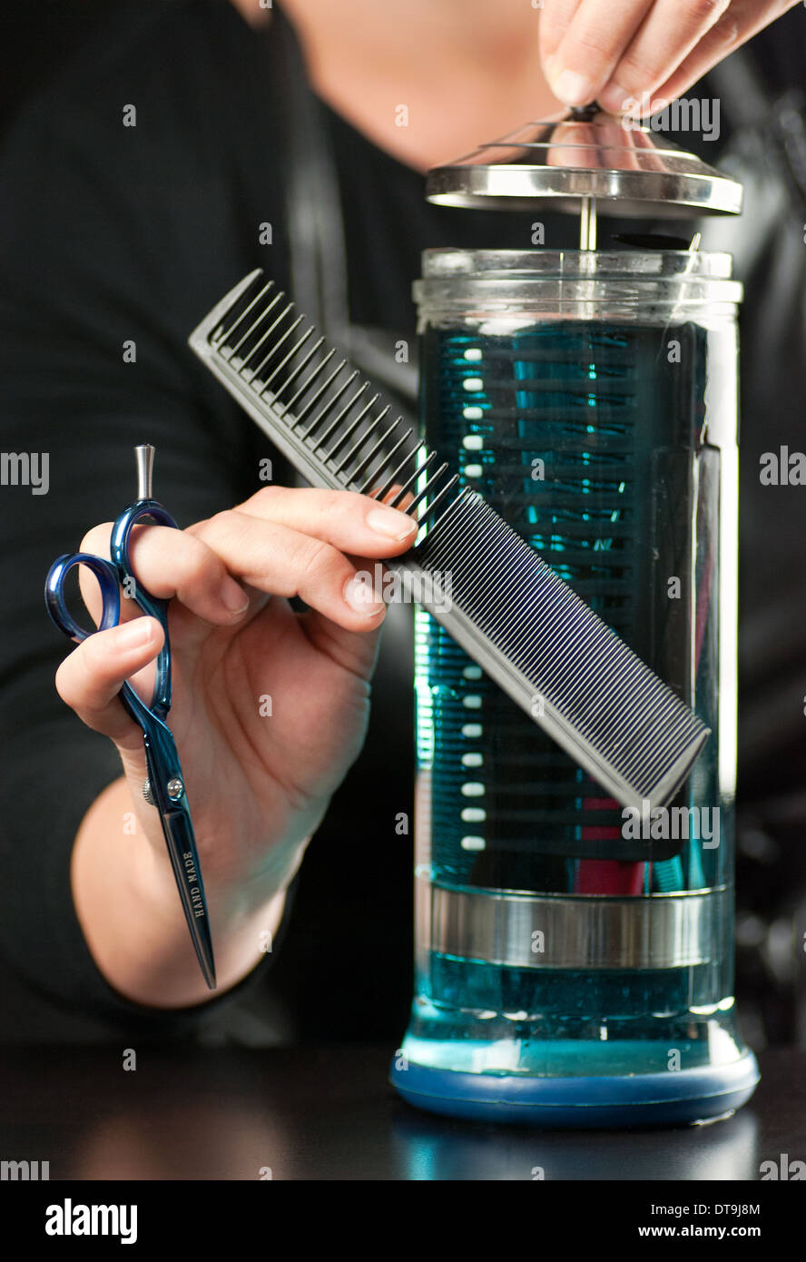 Stylist Places Comb In Disinfectant Stock Photo