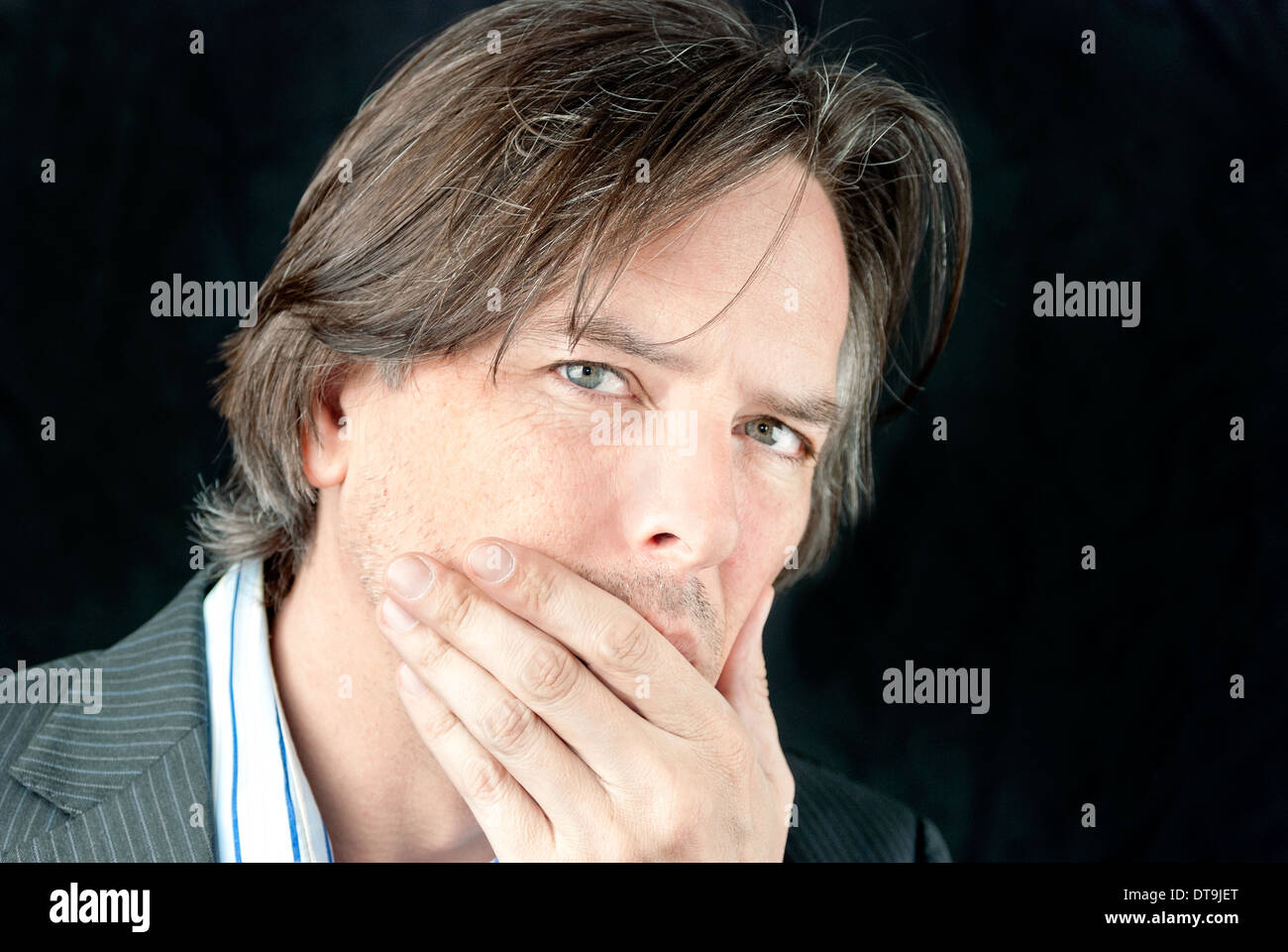 Close-up of a ill businessman covering his mouth. Stock Photo