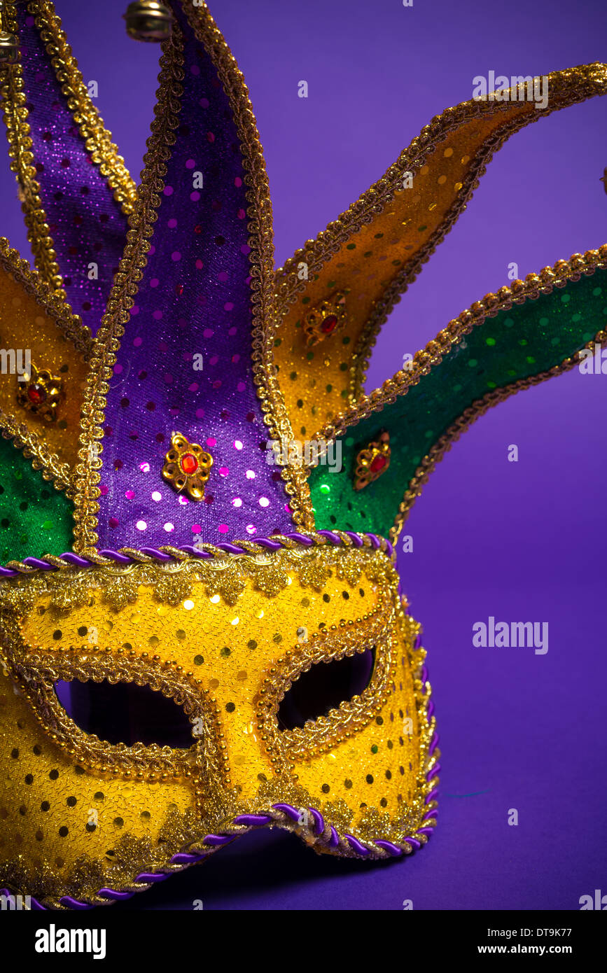 Festive mardi gras, venetian or jester mask on a purple background