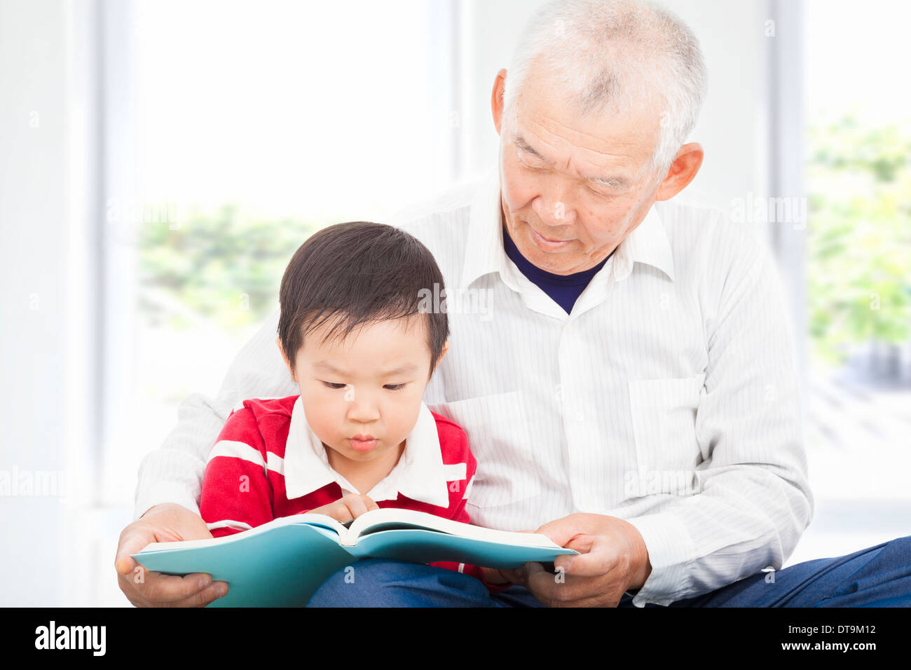 grandfather telling story to his grandson at home Stock Photo