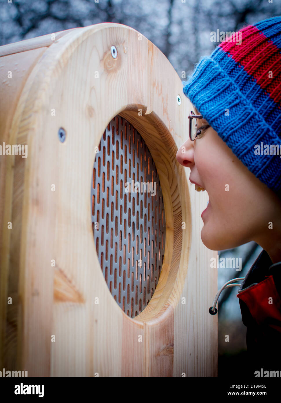 Boy Screams Into A Wooden Box Stock Photo