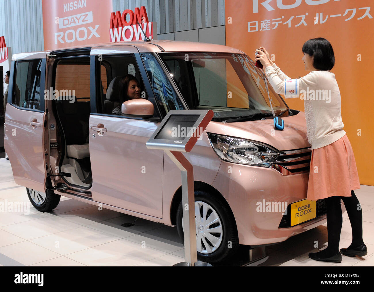 Yokohama, Japan. 13th Feb, 2014. People pose for photos with Japan's auto giant Nissan's new model Dayz Roox at the headquarters of Nissan Motor in Yokohama, Japan, Feb. 13, 2014. Nissan's Dayz Roox was released on Thursday throughout Japan. © Stringer/Xinhua/Alamy Live News Stock Photo