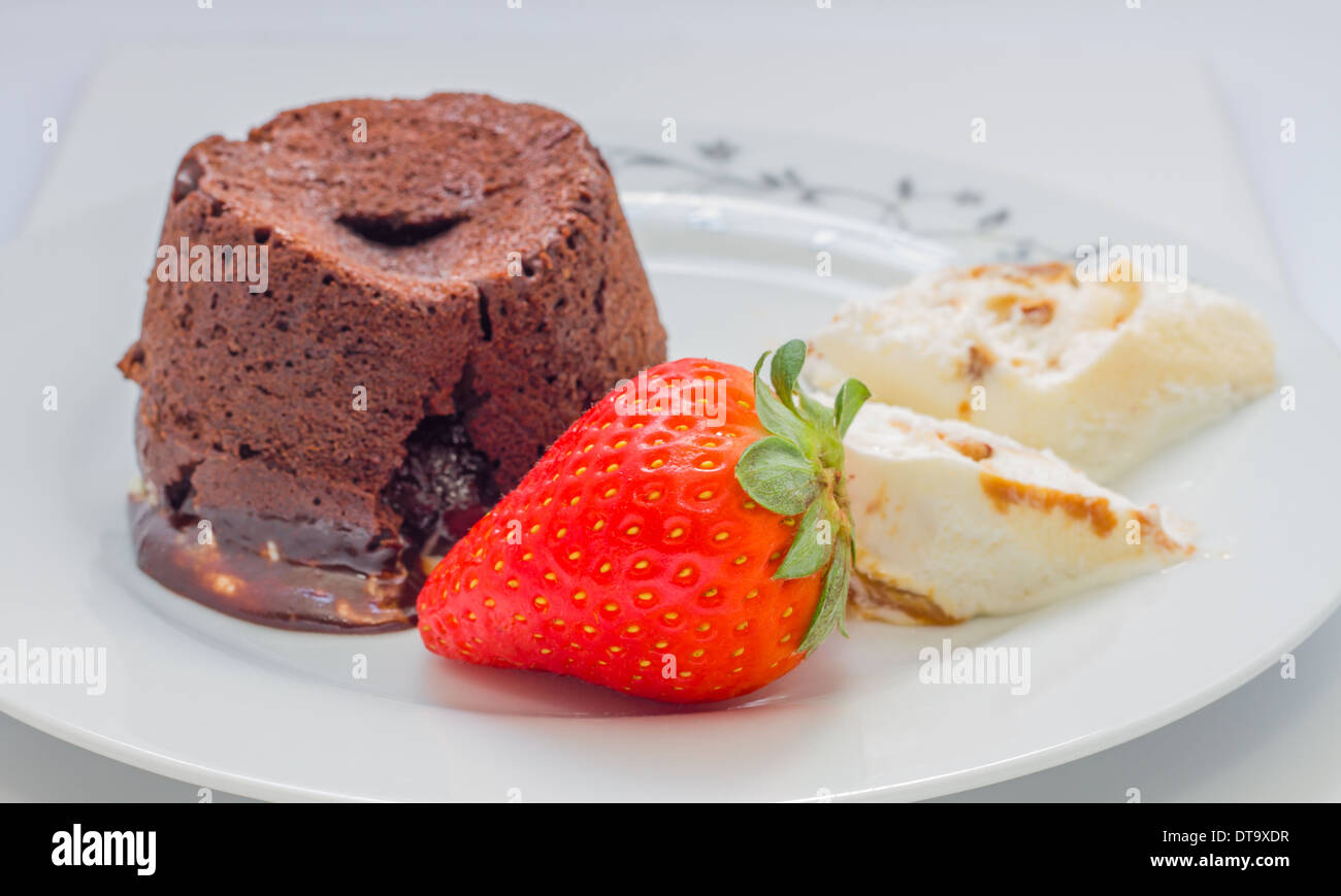 Chocolate cake volcano with creamy ice cream and strawberries Stock