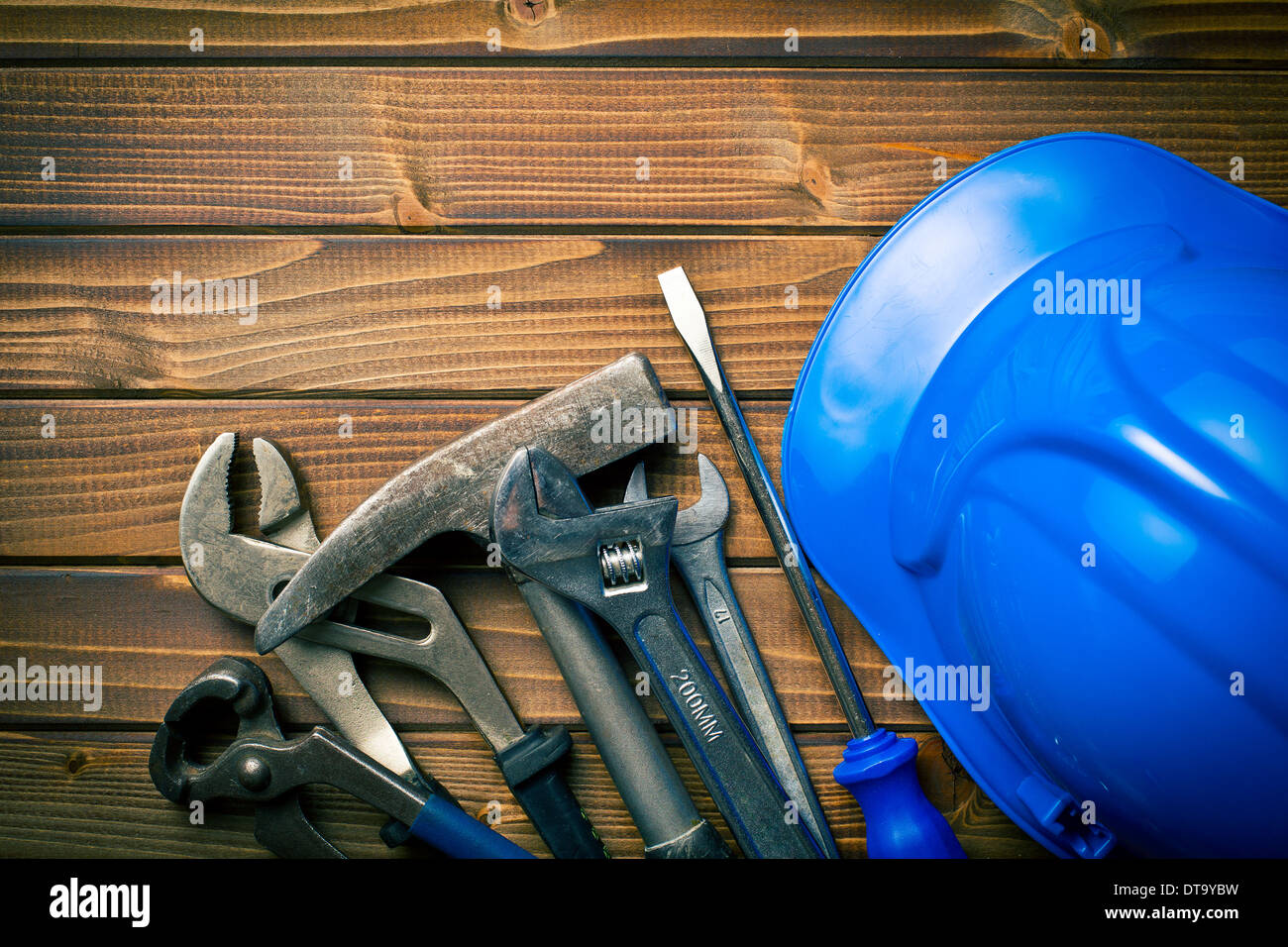 hard hat with various working tools on wooden background Stock Photo