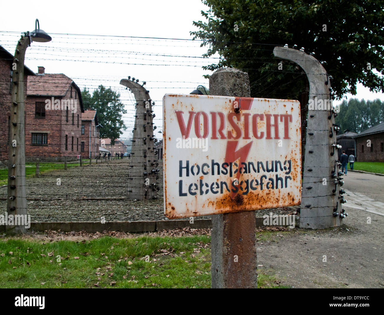 A warning sign for high voltage in the fence at the Nazi Concentration Camp in Auschwitz in Poland Stock Photo