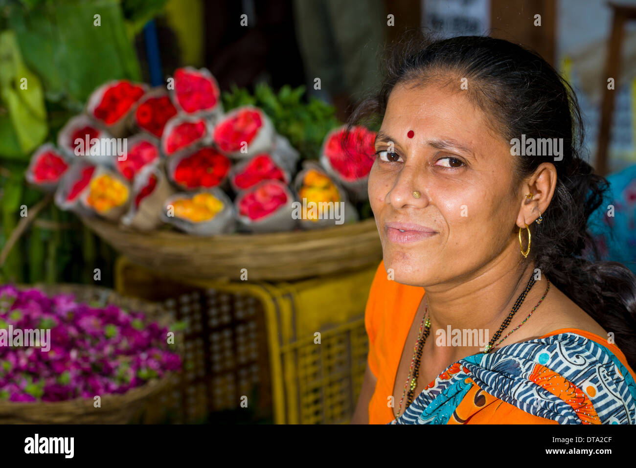 Portrait of a woman selling flowers at an open air market, Mumbai, Maharashtra, India Stock Photo