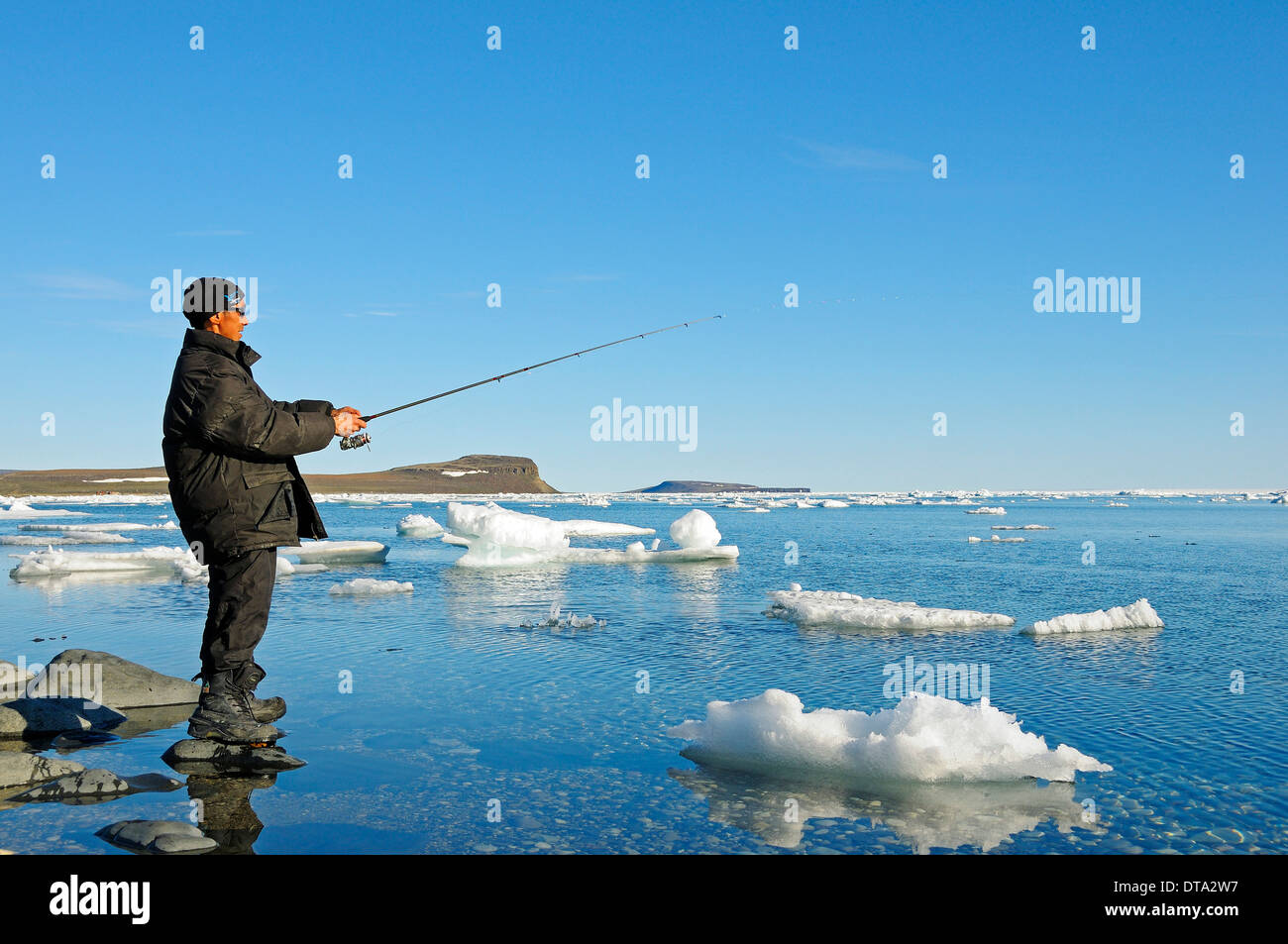 Man of the Inuit people fishing on the banks of the Beaufort Sea, Arctic Ocean, Victoria Island, formerly Holman Island Stock Photo