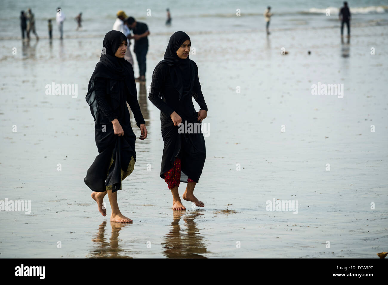 two-muslim-girls-walking-along-juhu-beach-mumbai-maharashtra-india-DTA3PT.jpg