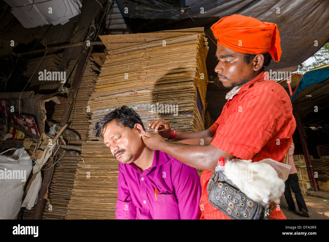 An ear cleaner at work at Mangaldas Market, Mumbai, Maharashtra, India Stock Photo