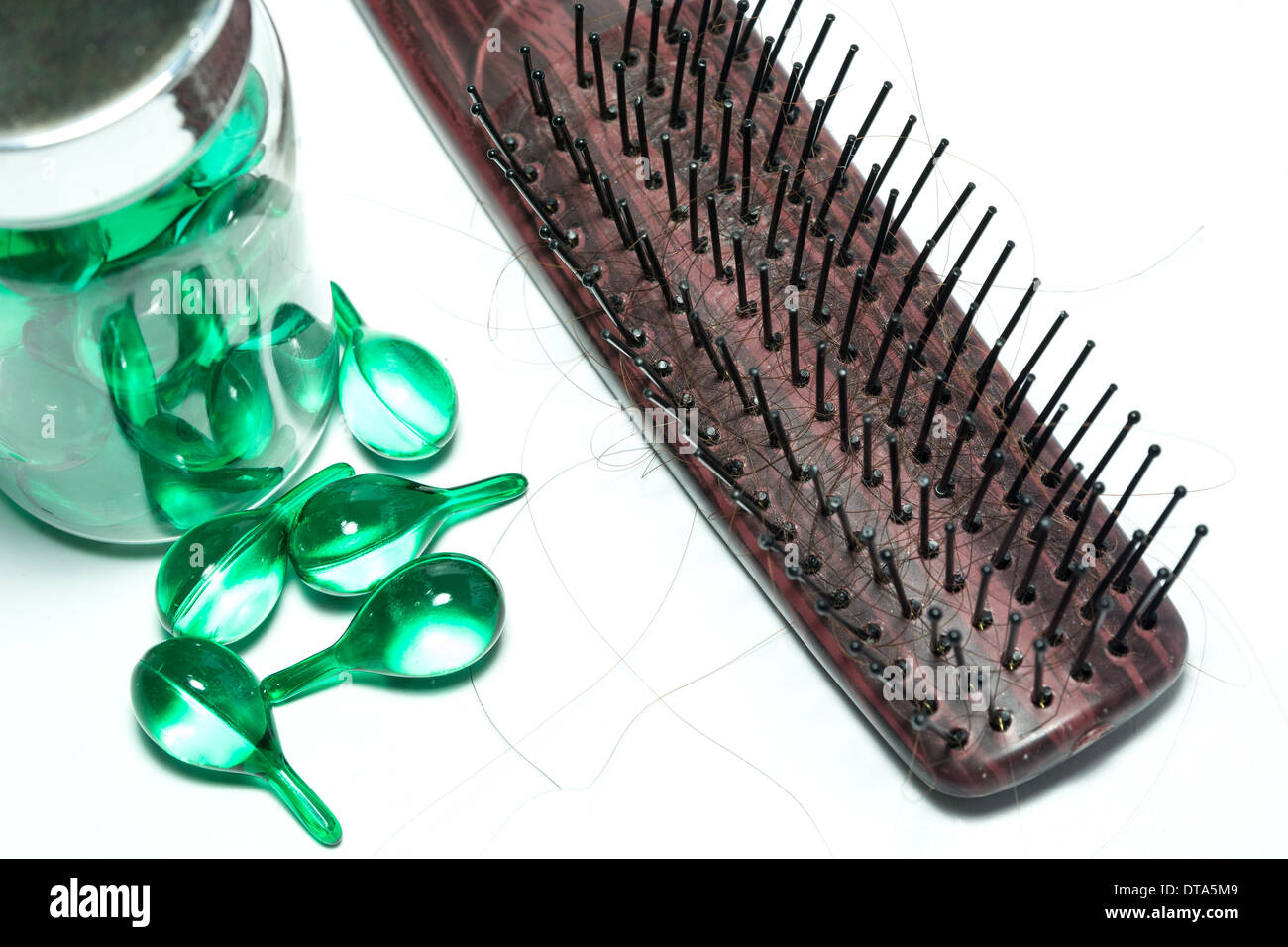 hair vitamins and Hairbrush with Hair Loss on white background Stock Photo