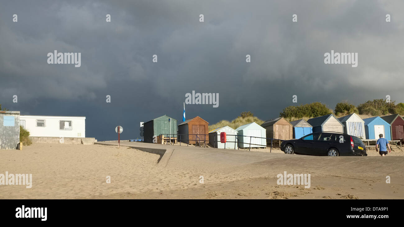 A Stormy sky above Abersoch beach huts before the damage caused by winter storms and high tides of 2014. Car parked on the slipw Stock Photo