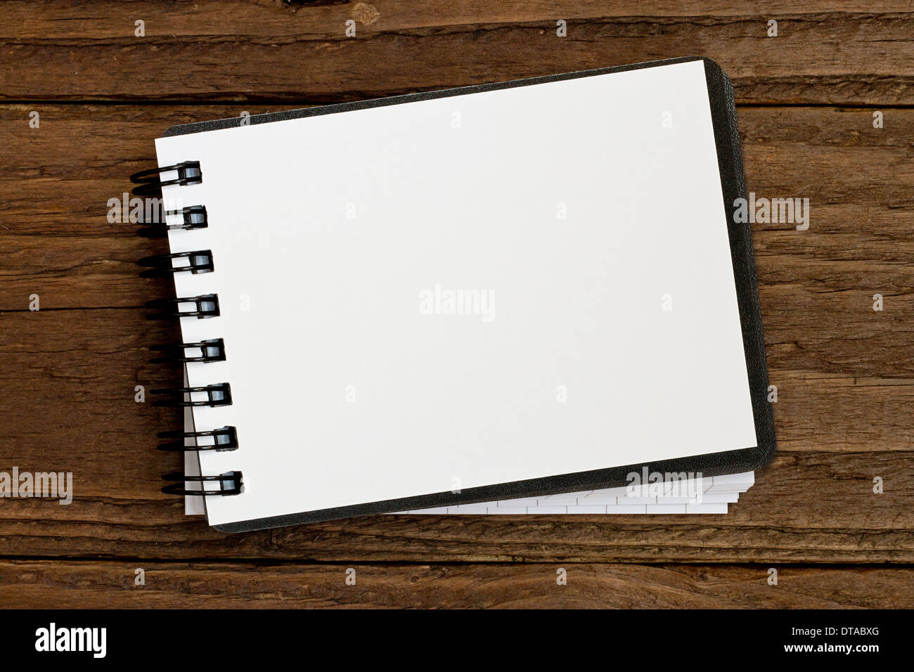 Small blank notepad in landscape orientation against a rustic wooden background Stock Photo