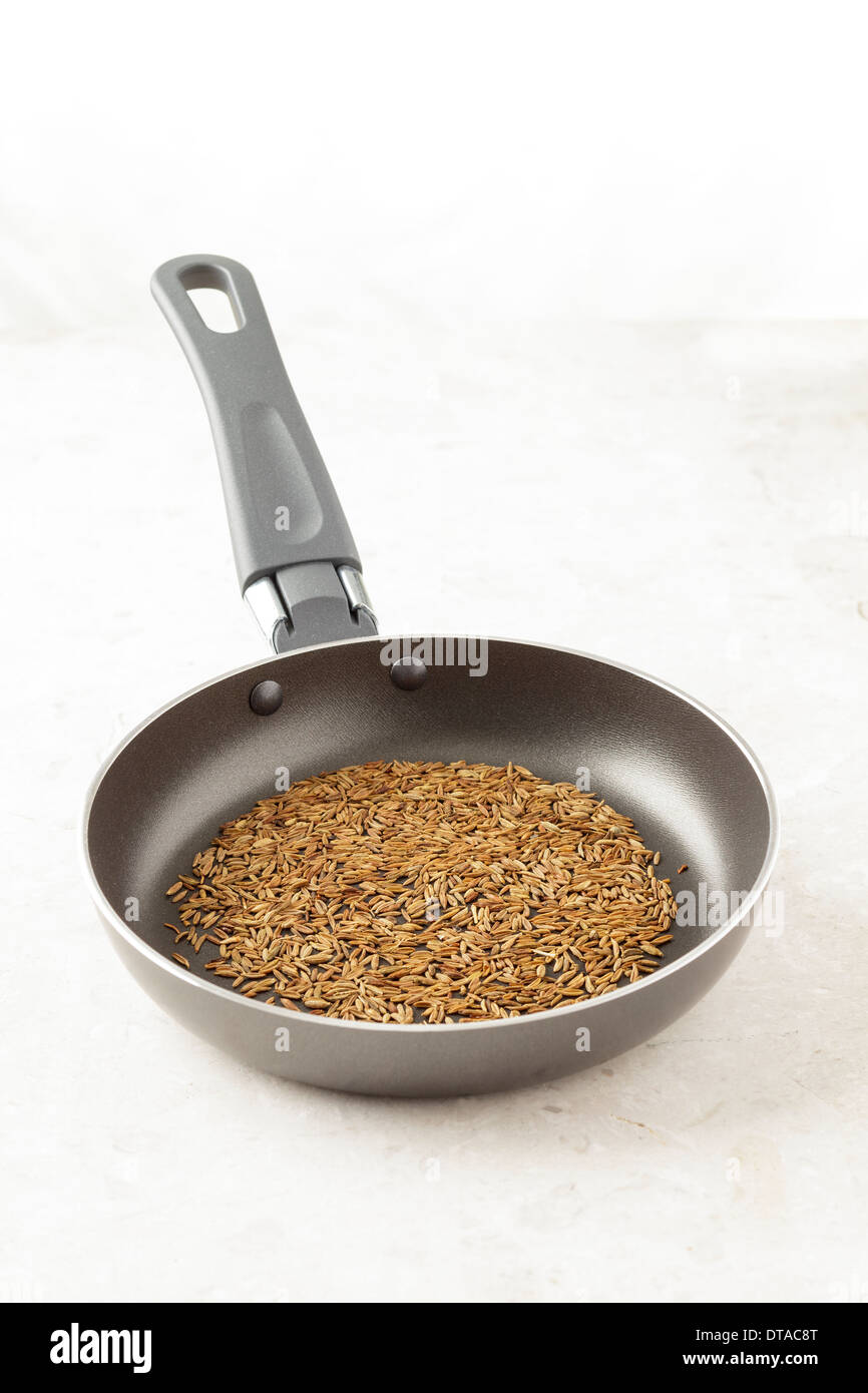 Cumin Seeds roasted in small pan Stock Photo