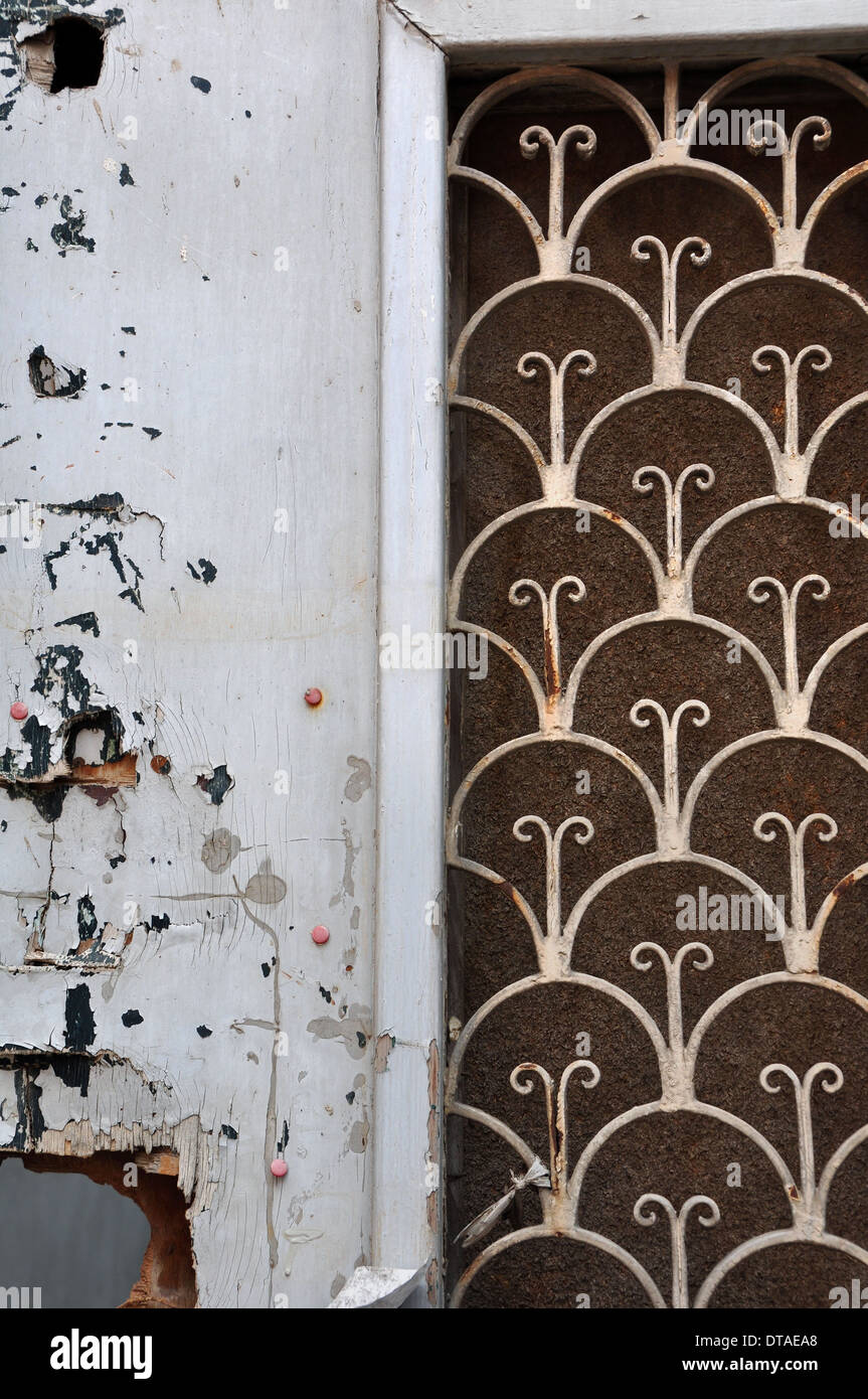 Broken wooden door with vintage rusty metal pattern and peeling paint. Abstract background. Stock Photo
