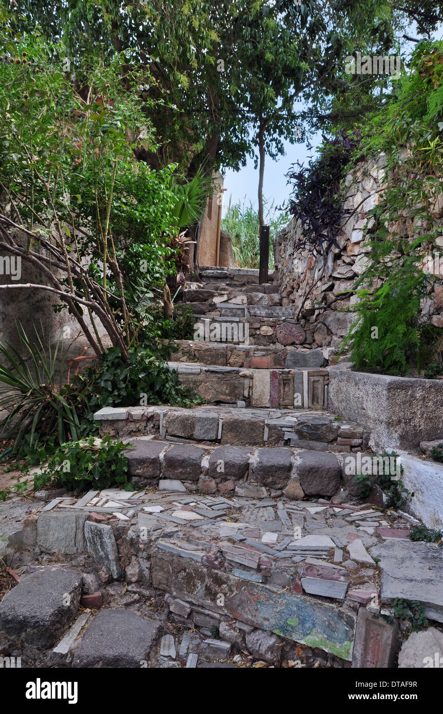 Stone steps decorated with ancient Greek symbols. Picturesque narrow street below the Acropolis rock in Plaka, Athens Greece. Stock Photo